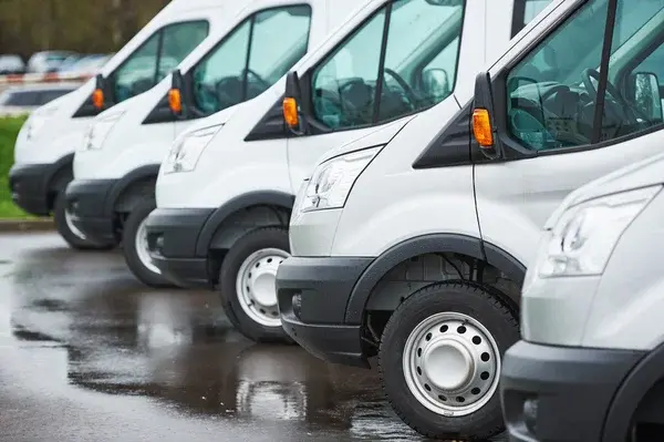 A row of white fleet vans